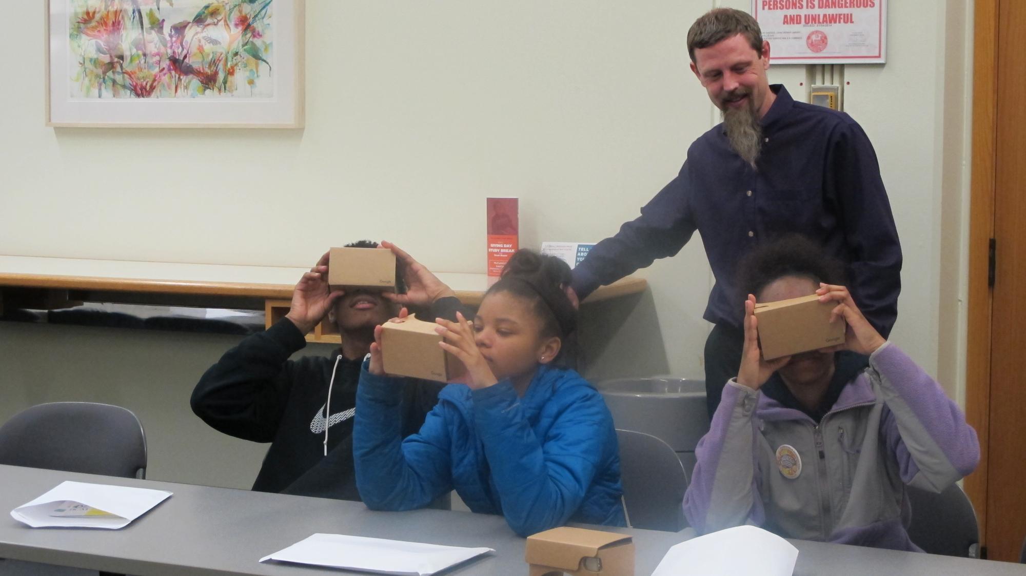 RCC digital humanities expert Jeff Tharsen watches over UCW students trying out Google Cardboard for the first time.